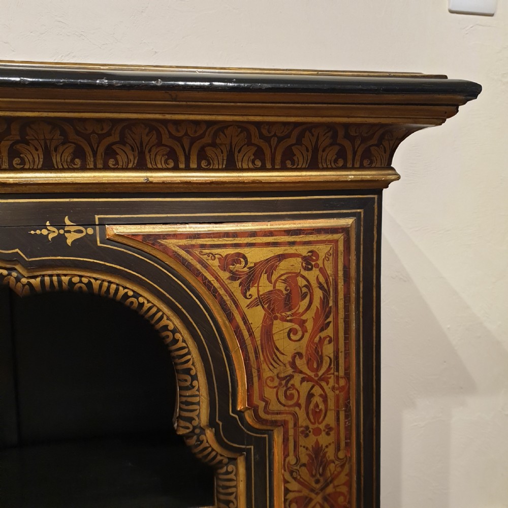 An ebonised open bookcase with gilded & faux boulle decoration View II