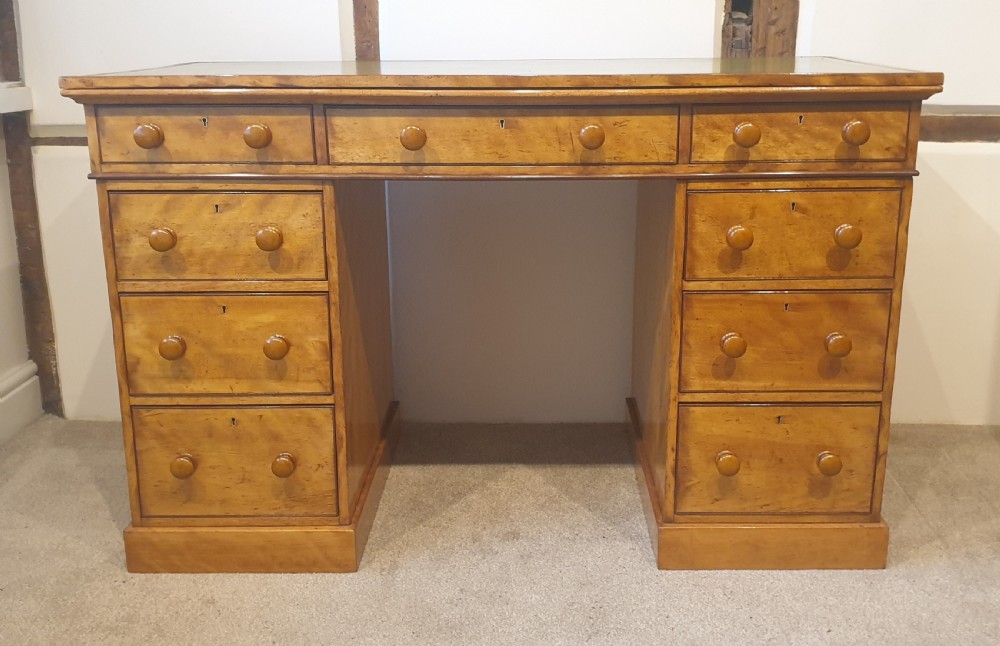 A 19th-century satin birch pedestal desk featuring nine drawers with turned wooden handles and a green leather inset writing surface. View II