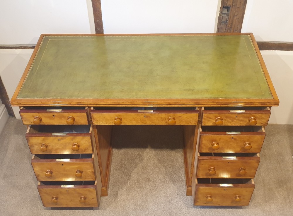 A 19th-century satin birch pedestal desk featuring nine drawers with turned wooden handles and a green leather inset writing surface. View III