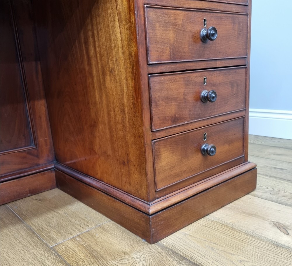 An early nineteenth-century mahogany pedestal desk featuring a raised tray top, nine drawers with turned wooden handles, and a central kneehole. View XI