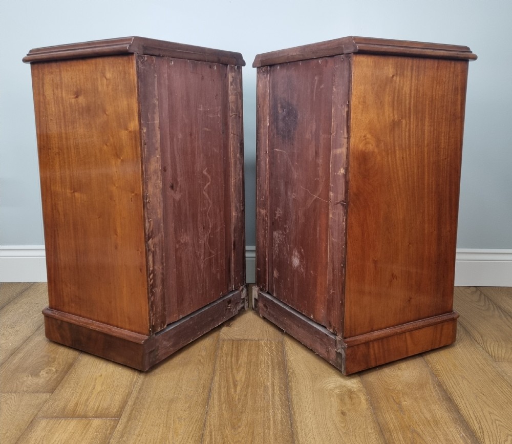 A fine pair of mahogany pedestal bedside chests with brushing slides View X