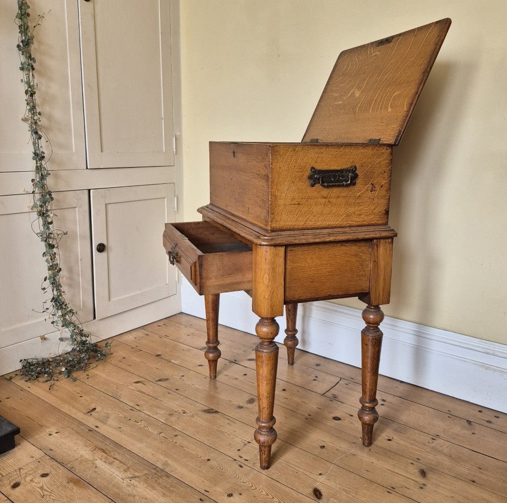 A late 19th-century golden oak ticket collecting box with internal compartments set atop a matching turned-leg stand. View V