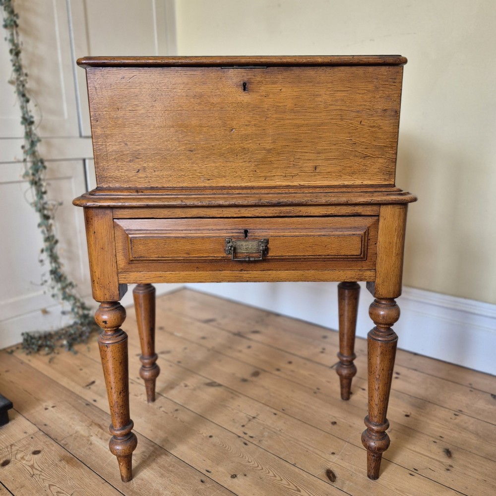 A late 19th-century golden oak ticket collecting box with internal compartments set atop a matching turned-leg stand. View VI