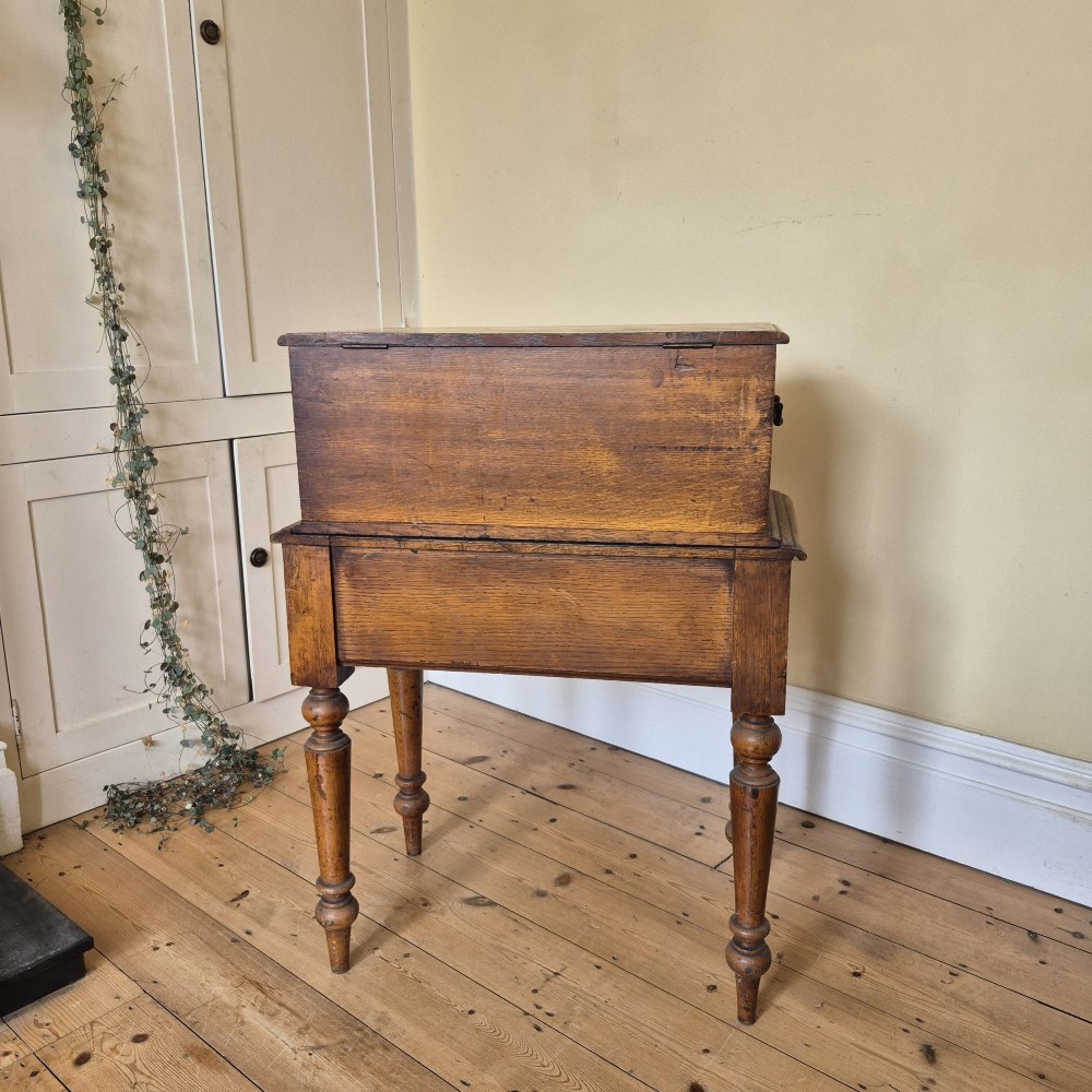 A late 19th-century golden oak ticket collecting box with internal compartments set atop a matching turned-leg stand. View X
