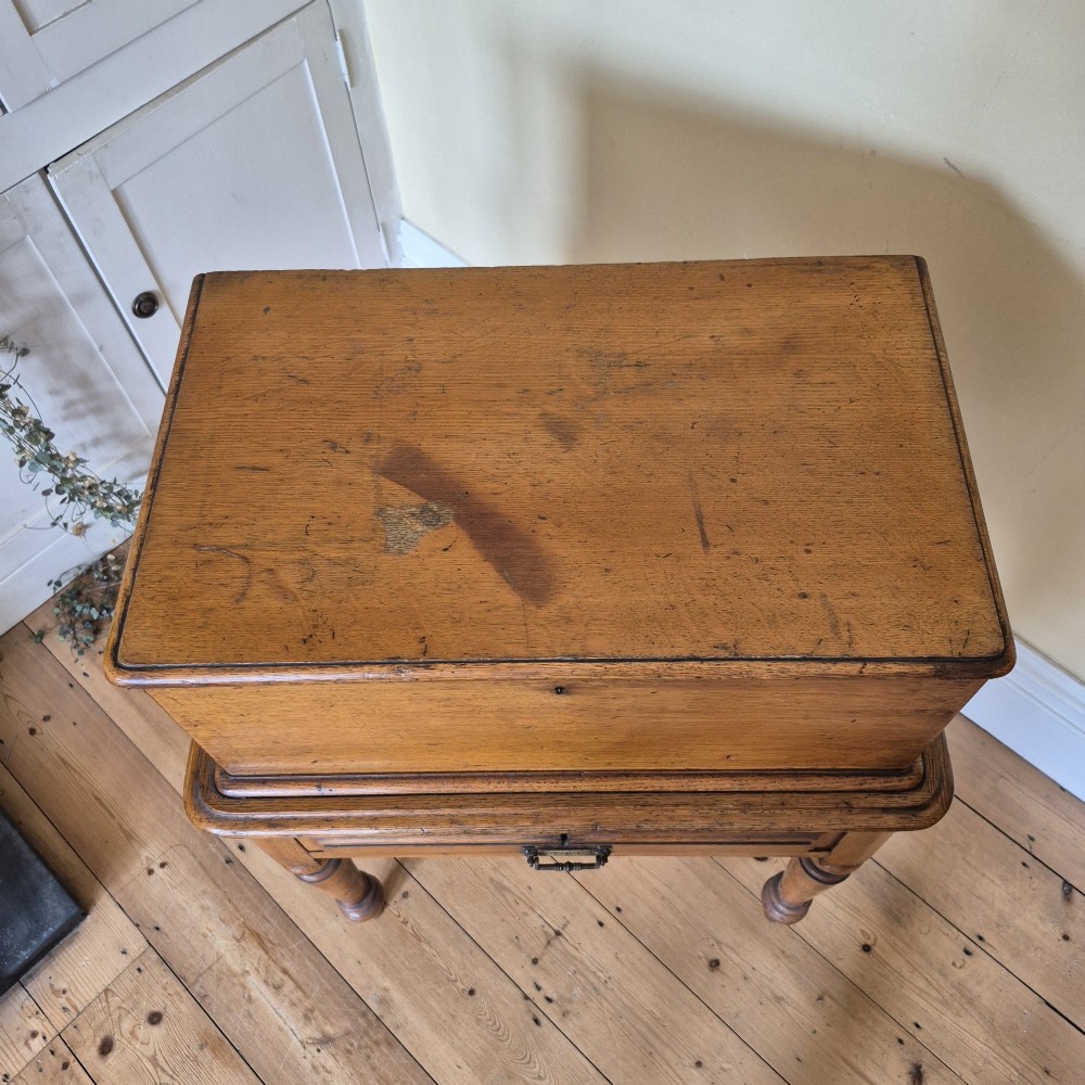 A late 19th-century golden oak ticket collecting box with internal compartments set atop a matching turned-leg stand. View XI