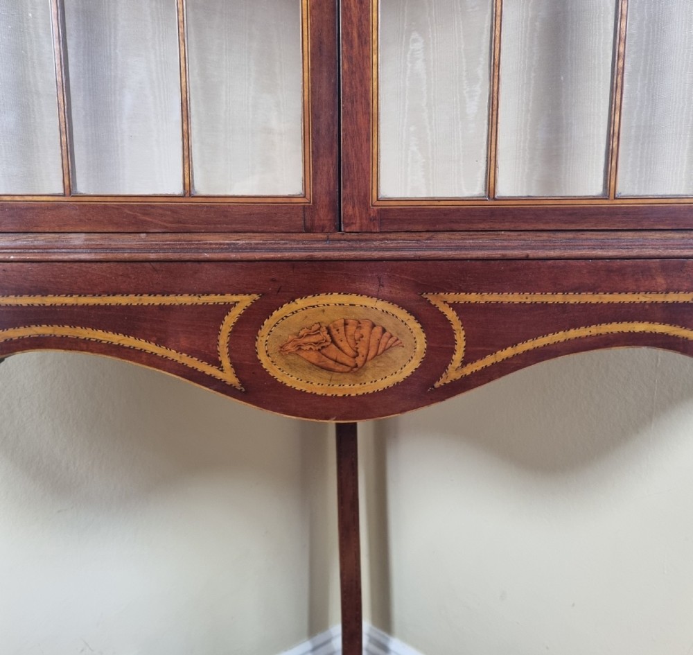 A mahogany Georgian corner display cabinet on stand featuring gothic astragal glazed doors, a swan-neck pediment, marquetry inlays, and curved lower legs. View VI