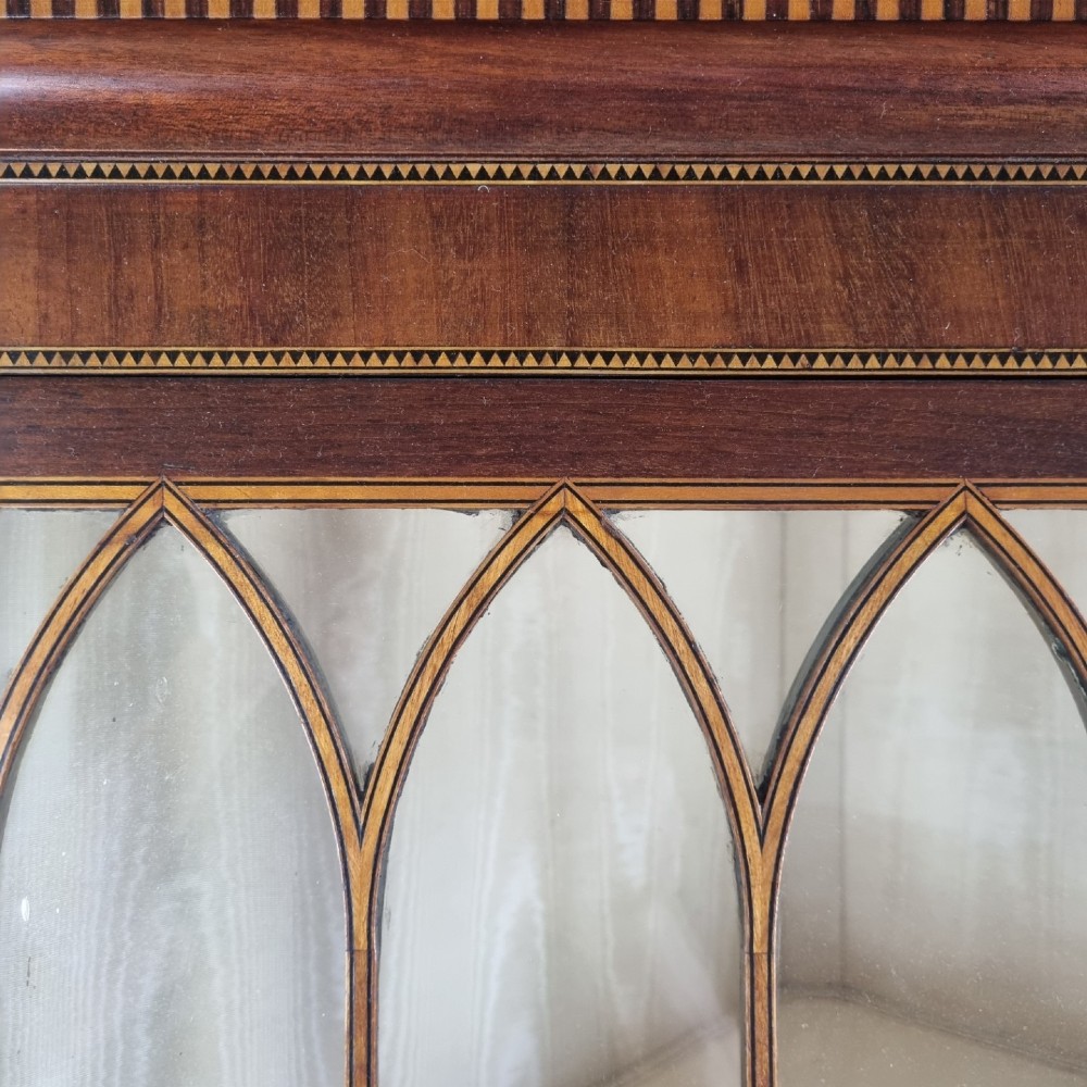 A mahogany Georgian corner display cabinet on stand featuring gothic astragal glazed doors, a swan-neck pediment, marquetry inlays, and curved lower legs. View VIII