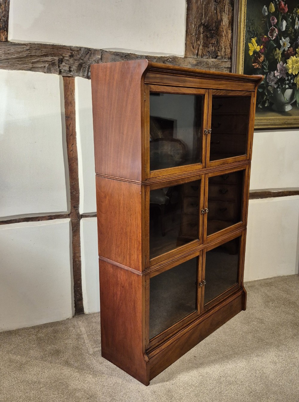 A three-tier warm brown oak sectional bookcase with double glazed doors and brass ring handles. View III