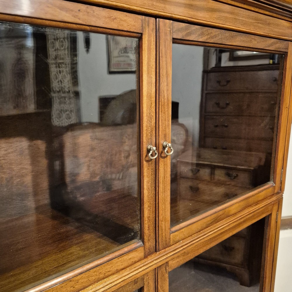 A three-tier warm brown oak sectional bookcase with double glazed doors and brass ring handles. View VI