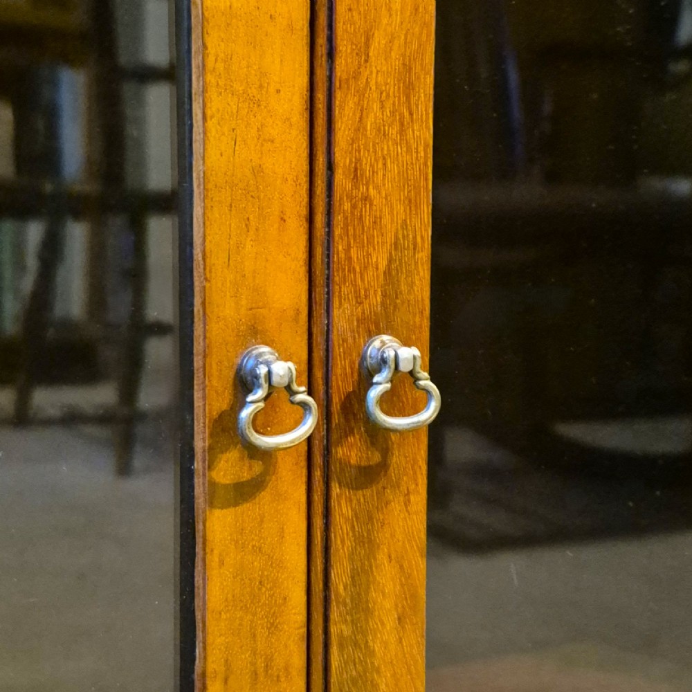 A three-tier warm brown oak sectional bookcase with double glazed doors and brass ring handles. View VII