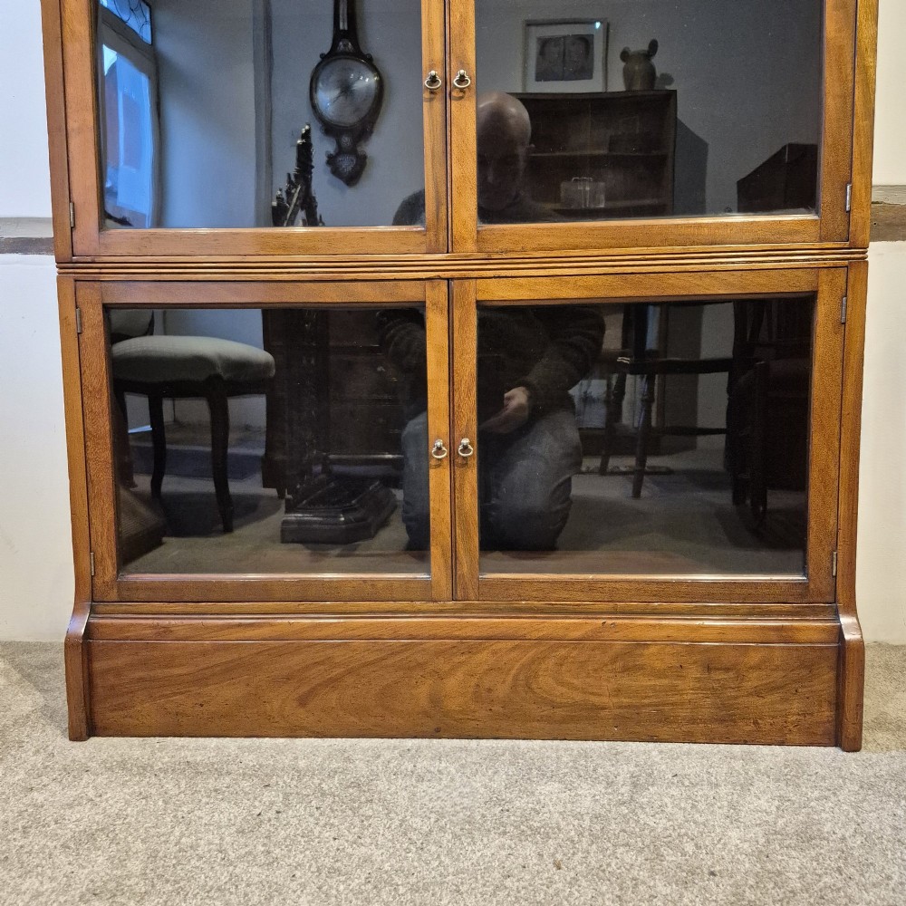 A three-tier warm brown oak sectional bookcase with double glazed doors and brass ring handles. View VIII