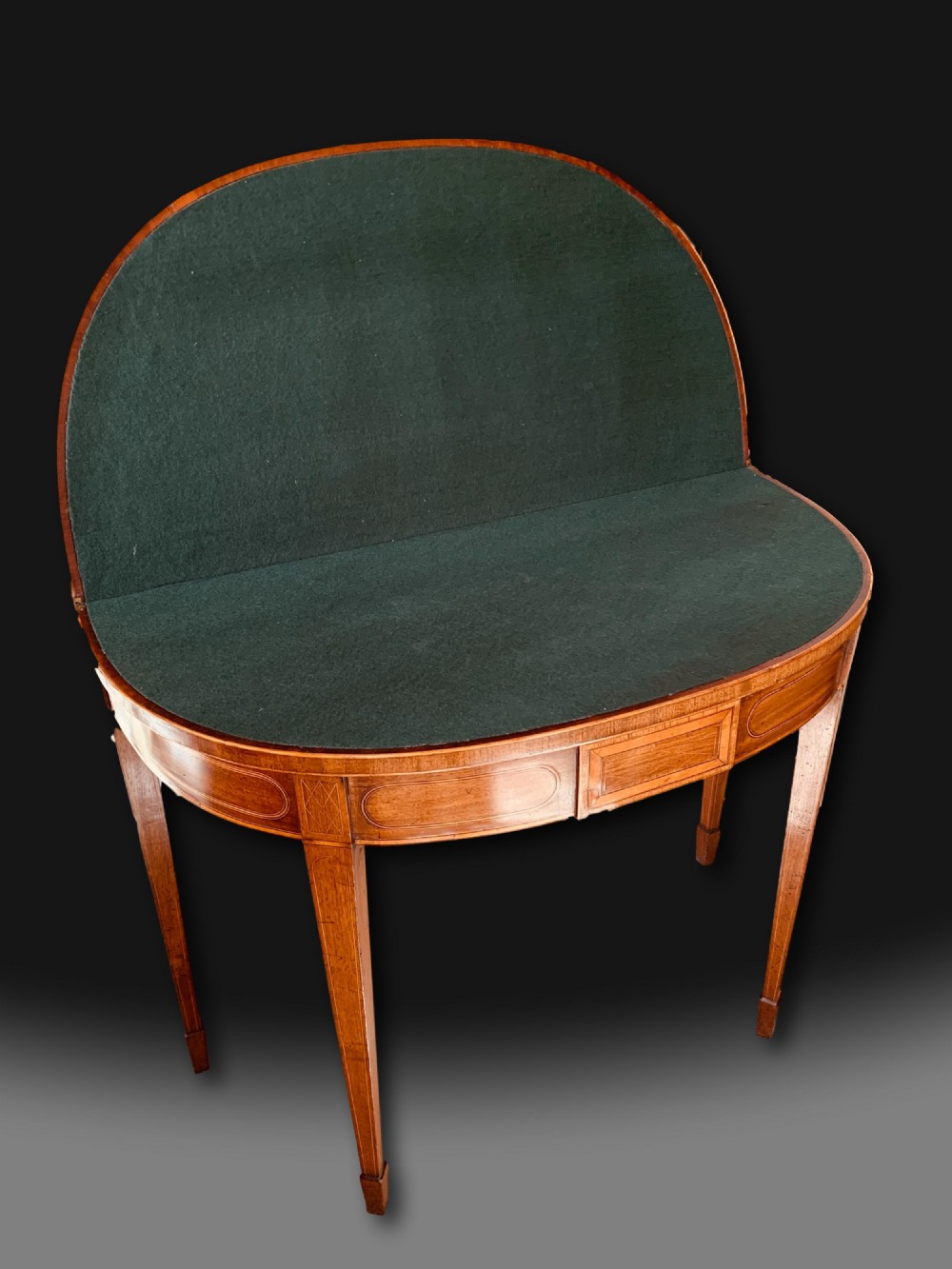 A George III semi-circular mahogany card table featuring crossbanded inlay panels and square tapered legs. View III