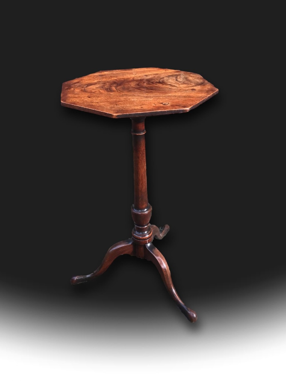 A George III mahogany tripod table featuring an octagonal top, a turned central column, and three splayed legs.