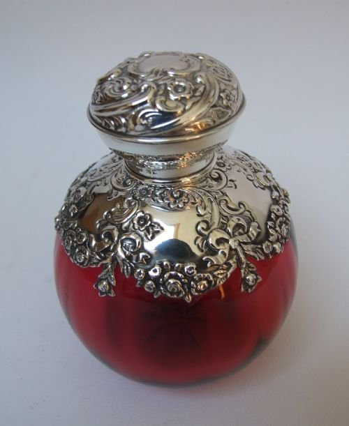 fig 1. A rare Edwardian silver shouldered and lidded cranberry cologne bottle.