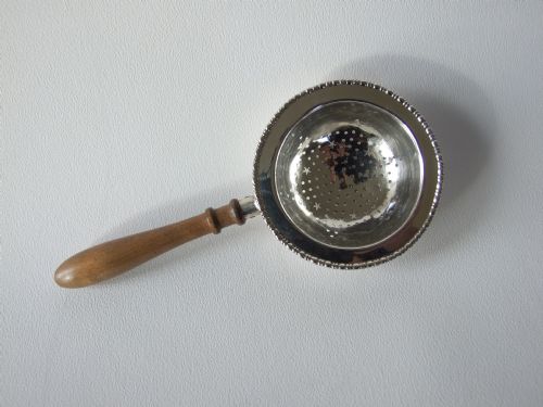 A Fine Silver Tea Strainer with Turned Wooden Handle.