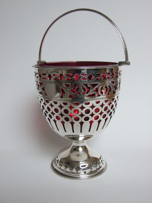 A Spectacular Pierced Silver Sweetmeat Basket with Cranberry Liner.