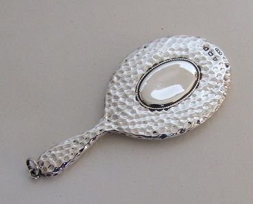 An Arts & Crafts Hammered Silver Chatelaine Mirror.