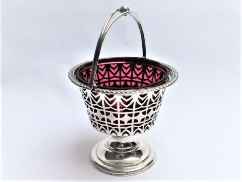 An Edwardian Silver and Cranberry Swing Handle Basket.