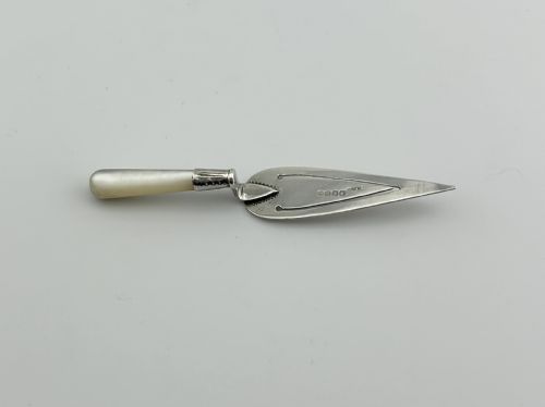fig 1. A trowel-shaped sterling silver page clip featuring a carved mother-of-pearl handle and stamped Glasgow hallmarks on the blade.