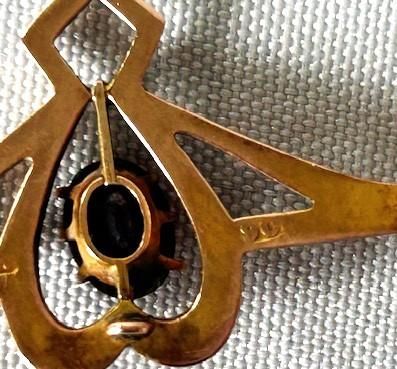 fig 2. An Edwardian 9ct gold brooch featuring a central openwork heart motif encasing a claw-set oval amethyst on a horizontal bar frame.