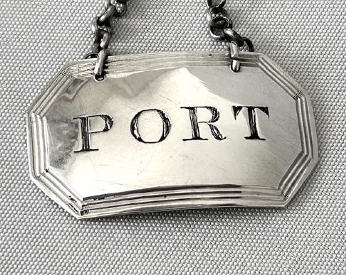 fig 1. An octagonal Georgian sterling silver decanter label engraved with the word PORT, featuring a reeded border and chain.