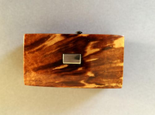 fig 1. A mid-19th-century rectangular tortoiseshell snuff box featuring a curved top lid and a blank silver cartouche inlay.