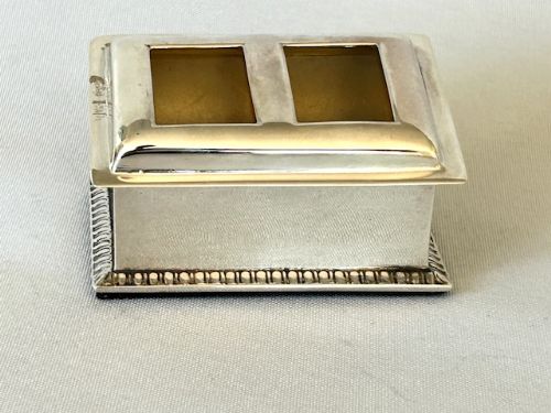 fig 1. An Edwardian silver double stamp box featuring two square lid apertures, sloped sides, and a gadrooned lower border.
