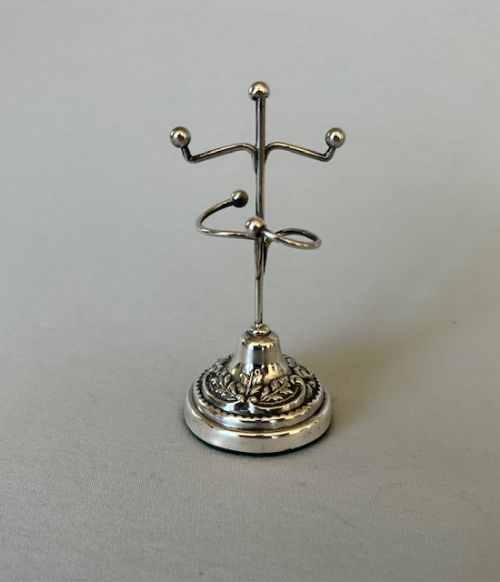 fig 1. An Edwardian sterling silver ring tree featuring a slender central stem with branched arms and a round embossed base.