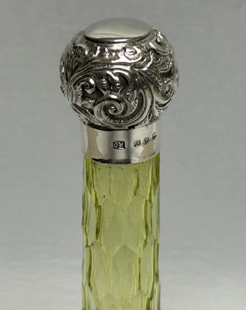 fig 2. A Victorian yellow cut glass cologne bottle featuring a faceted neck, diamond-patterned base, and an embossed sterling silver cap.