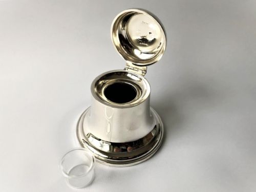 fig 1. A polished George V silver novelty inkwell crafted in the shape of a bell with a hinged lid and flared base.