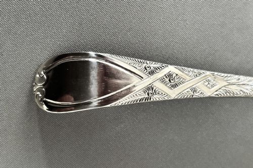 fig 1. A Georgian sterling silver sifter spoon featuring a pierced foliate bowl and an engraved handle stem.