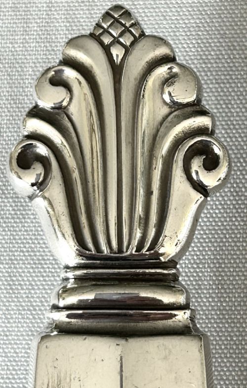 fig 1. A mid-century Georg Jensen silver serving slice featuring a faceted handle and sculpted leaf finial.