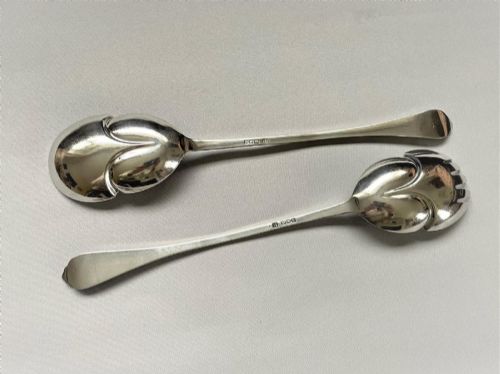 fig 1. A pair of Edwardian silver salad servers consisting of a spoon and a fork with stylized leaf-shaped bowls and scroll-embossed handle terminals.