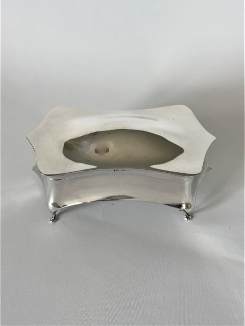 fig 1. A polished George V sterling silver trinket box featuring a shaped flared body, hinged lid, and four cabriole legs.