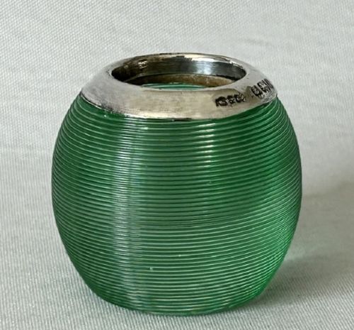 A spherical emerald green glass match striker featuring ribbed horizontal grooves and a hallmarked sterling silver collar at the rim. View III
