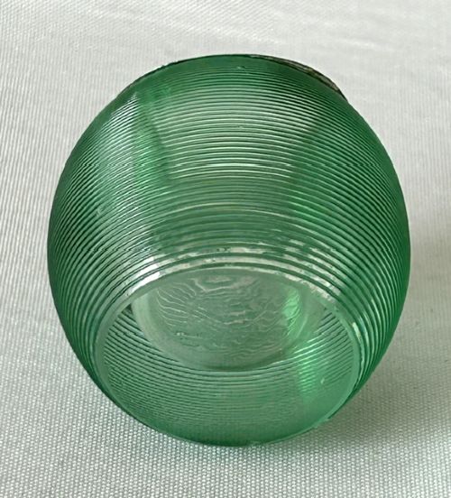 A spherical emerald green glass match striker featuring ribbed horizontal grooves and a hallmarked sterling silver collar at the rim. View IV