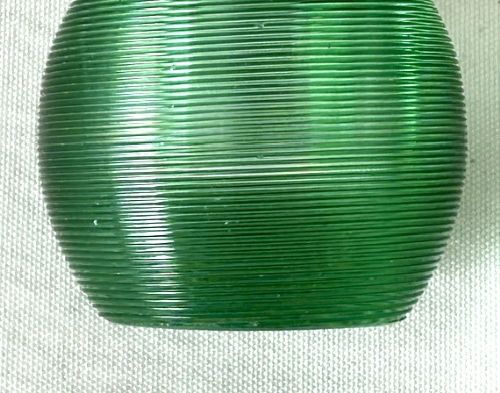 A spherical emerald green glass match striker featuring ribbed horizontal grooves and a hallmarked sterling silver collar at the rim. View V
