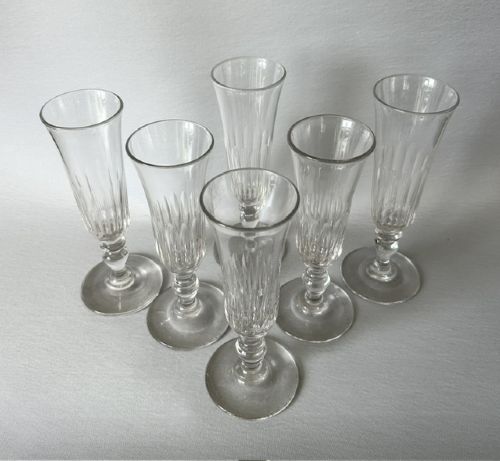fig 1. A set of six clear late Victorian champagne flutes featuring flared panel-cut bowls, knopped stems, and circular bases.