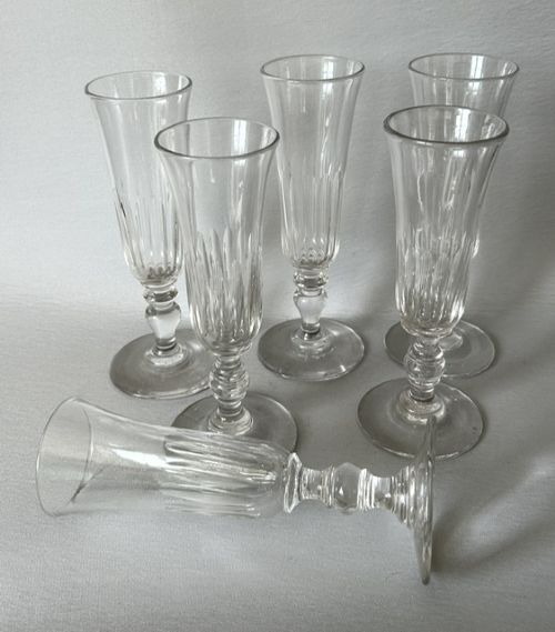 A set of six clear late Victorian champagne flutes featuring flared panel-cut bowls, knopped stems, and circular bases. View III