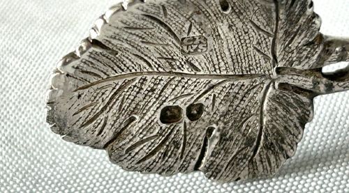 A pair of Victorian cast silver tea tongs designed with naturalistic vine branch handles, leaf motifs, and leaf-shaped grips. View VI