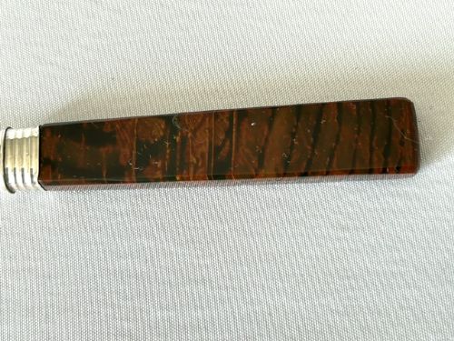 A Victorian silver dessert knife and fork featuring engraved scrollwork on the blade and tines with polished rectangular dark brown agate handles. View VI