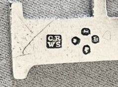 fig 1. An early Victorian silver decanter label formed in the shape of the letter P and suspended on a silver chain.