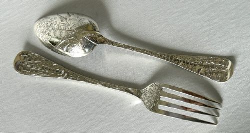 A late Victorian silver spoon and fork with engraved pattern detailing, displayed inside an open dark green velvet-lined presentation box with a cream silk interior. View VIII