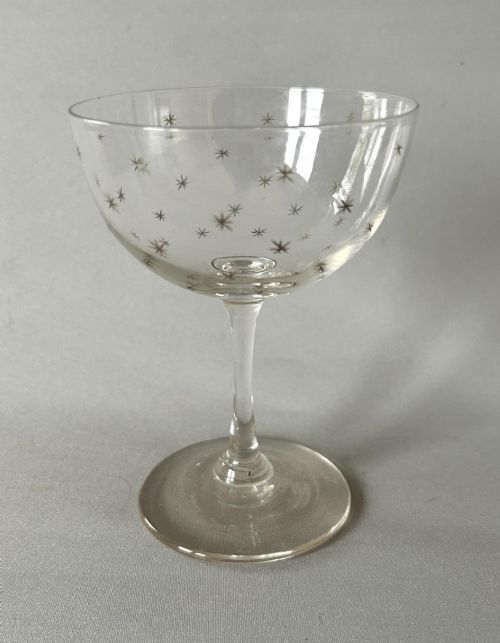 fig 1. A harlequin set of six clear Victorian glass champagne coupes featuring varied etched motifs including starbursts and Greek key patterns.