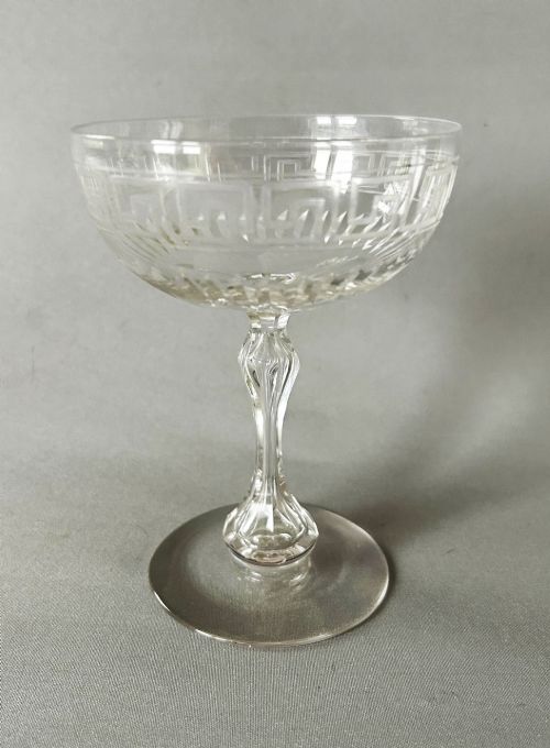fig 2. A harlequin set of six clear Victorian glass champagne coupes featuring varied etched motifs including starbursts and Greek key patterns.