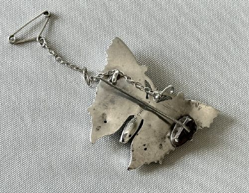 A Victorian sterling silver butterfly brooch detailed with applied rose gold stars and floral motifs, set with a central oval green stone. View III