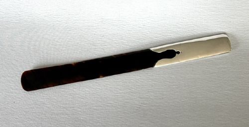 An Edwardian page turner featuring a smooth dark tortoiseshell blade attached to a polished silver mount. View III