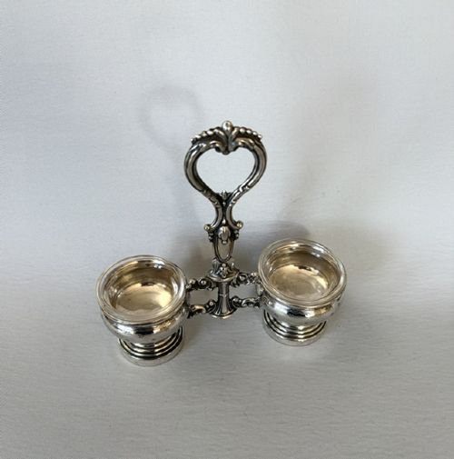fig 1. An antique French silver double condiment stand with a central scroll handle and two circular glass-lined holders.