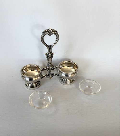 An antique French silver double condiment stand with a central scroll handle and two circular glass-lined holders. View V