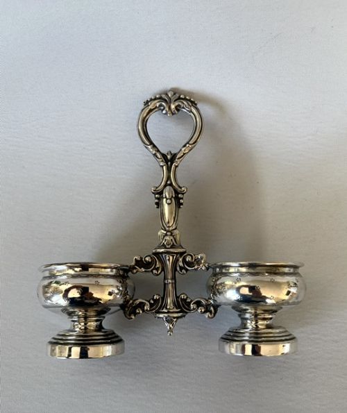 An antique French silver double condiment stand with a central scroll handle and two circular glass-lined holders. View VI